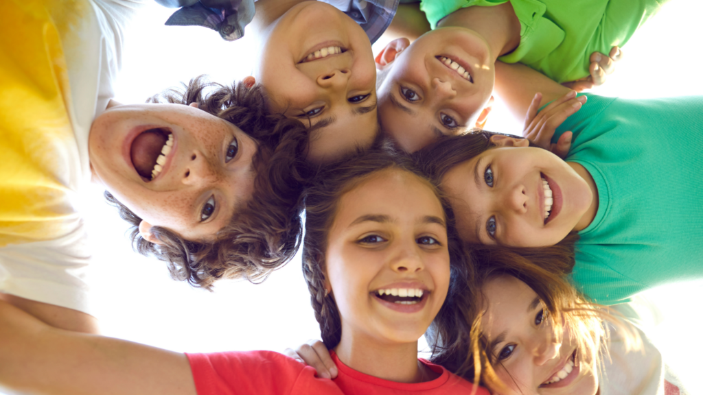 Viele Kinder schauen von oben in die Kamera