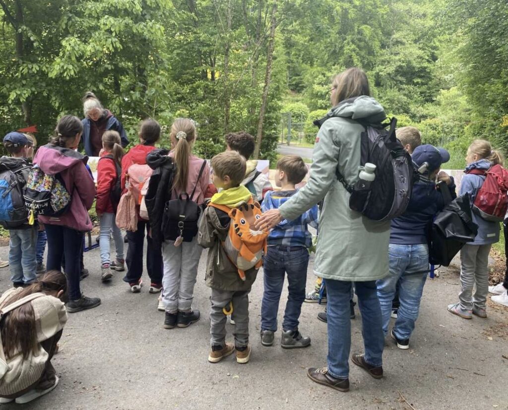 Schulklasse gemeinsam mit Förster im Wald